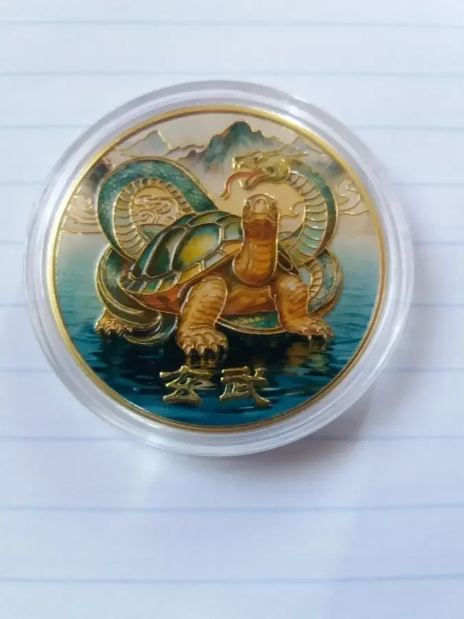 Монета черепаха обвита змією.