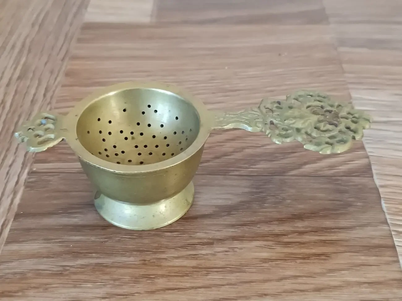 Антикварне ситечко для чаю в стилі бароко з чашею.