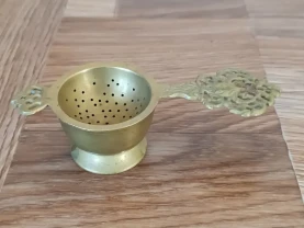 Антикварне ситечко для чаю в стилі бароко з чашею.