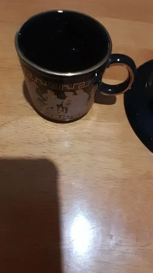 Кофейная черная чашка с изображением людей, украшена золотыми узорами 8